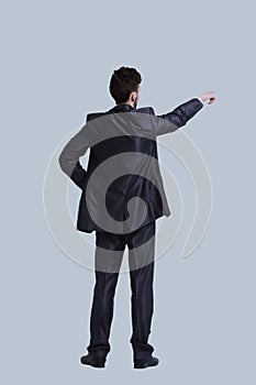 Young business man in a suit pointing with his finger