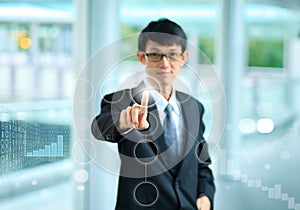 Young business man in a suit pointing with his finger to touch s