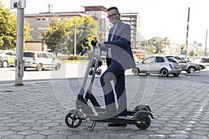 Young business man in a suit riding an electric scooter on business meeting. Ecological transportation concept. rent an