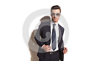 young business man with sunglasses opening his coat