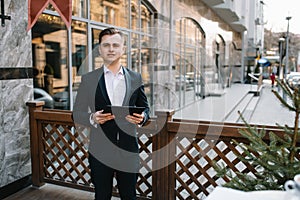 Young business man with tablet near of modern building