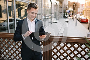 Young business man with tablet near of modern building