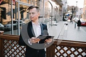 Young business man with tablet near of modern building