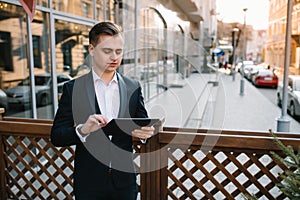 Young business man with tablet near of modern building