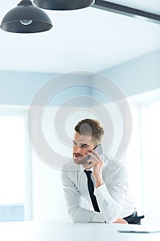 Young Business Man Talking on Cell Phone at Modern Office