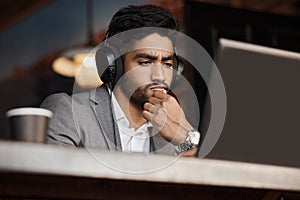 Young business man, thinking and coffee shop with headphones, laptop or plan for schedule, report or analysis. Indian