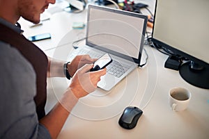 Young business man typing at cell phone at his workplace. business communication concept