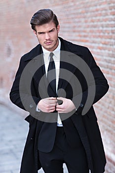 Young business man unbuttons jacket