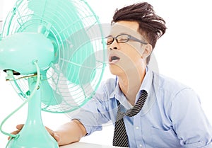 Young business man use fans to cool down