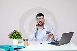 Young business man using credit card shopping online in office