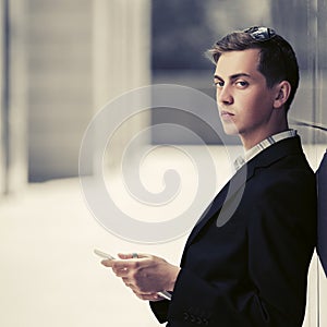 Young business man using digital tablet computer in city street