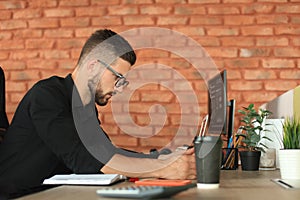 Young business man is using laptop while sitting in the office