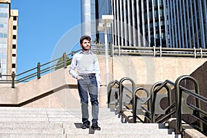 Young business man walking down stairs with a hand in his pocket