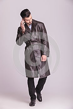 Young business man walking on studio background.