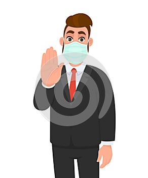 Young business man wearing medical mask and showing stop sign with hand palm. Trendy hipster person gesturing warning symbol.