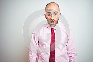 Young business man wearing pink tie over isolated background afraid and shocked with surprise expression, fear and excited face