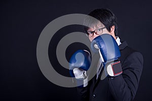 Young business man wearing suit with boxing gloves