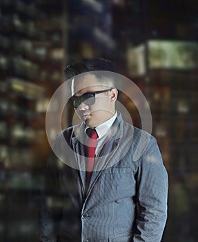 Young business man wearing suit and red tie with sunglasses giving a sophisticated look at night.
