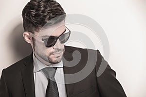 young business man wearing sunglasses looks away