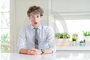 Young business man wearing a tie afraid and shocked with surprise expression, fear and excited face