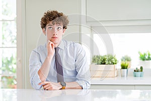 Young business man wearing a tie with hand on chin thinking about question, pensive expression