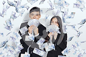 Young business man and woman showing the money under the money rain