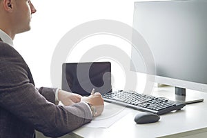Young business man working at the computer and papers on the table