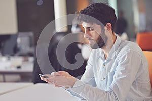 Young business man working on desktop computer at his desk in modern bright startup office interior