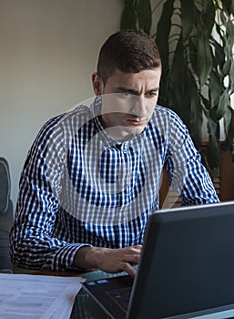 Young business man working on his laptop at home office