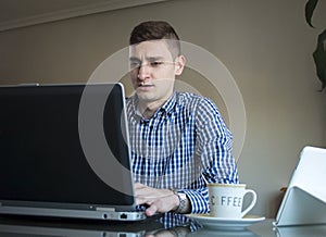 Young business man working on his laptop at home office