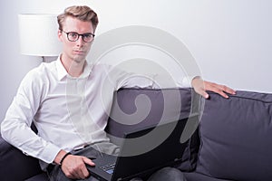 Young business man working at home on couch