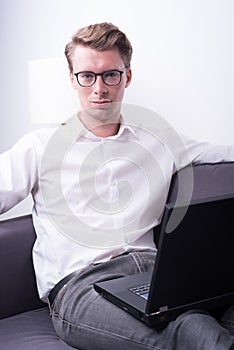 Young business man working at home on couch