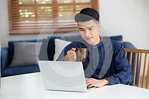 Young business man working from home with laptop computer on desk.