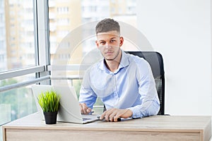 Young business man working at home with laptop and papers on desk