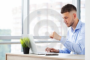 Young business man working at home with laptop and papers on desk