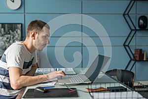 Young business man working on laptop at his desk in the office