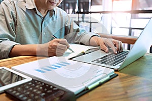 Young business man working sitting at desktop  computer at his desk in modern bright startup office, hard at work