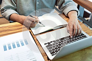 Young business man working sitting at desktop  computer at his desk in modern bright startup office, hard at work