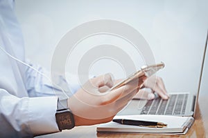 Young business men at table with smart phone and laptop computer, hipster millenial on line teamwork.