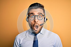 Young business operator man wearing customer service headset from call center afraid and shocked with surprise expression, fear