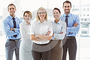 Young business people with arms crossed in office