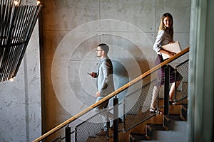 Young business people climb the stairs in the office building