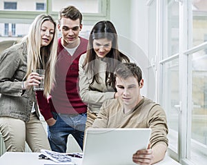 Young business people looking at laptop in meeting