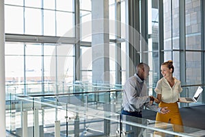 Young business people shaking hands in modern office lobby