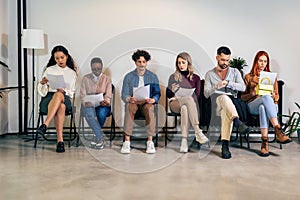 Young business people sitting in chairs and waiting for an interview