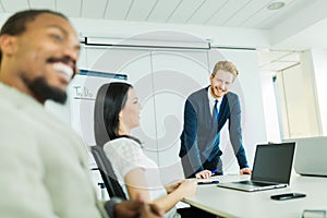 Young business people sitting at a conference table and learning