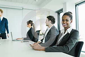 Young business people sitting at a conference table and learning