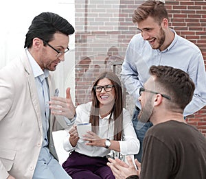 Young business people are talking and smiling during the coffee break in office