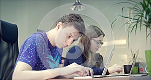 Young Business People Using Computer and Mobile Phone in the Office. Two Decorator`s Colleagues Working Together on an