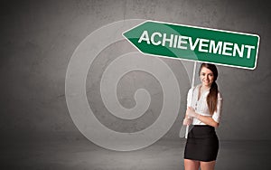 Young business person in casual holding road sign